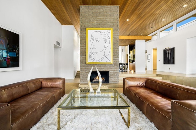 living room featuring a high ceiling, wooden ceiling, and a fireplace