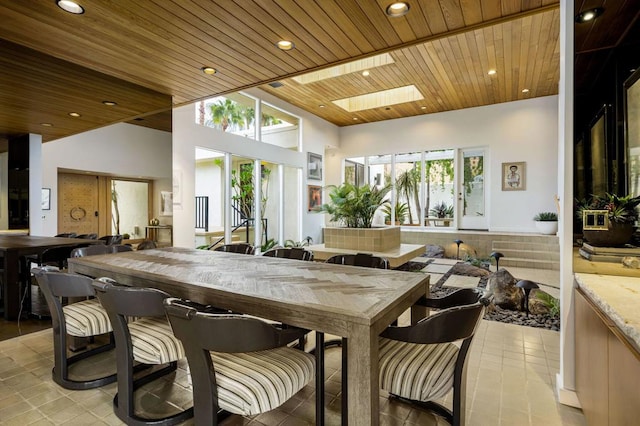 tiled dining area featuring a skylight and wooden ceiling