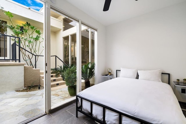 tiled bedroom featuring multiple windows, access to exterior, and ceiling fan