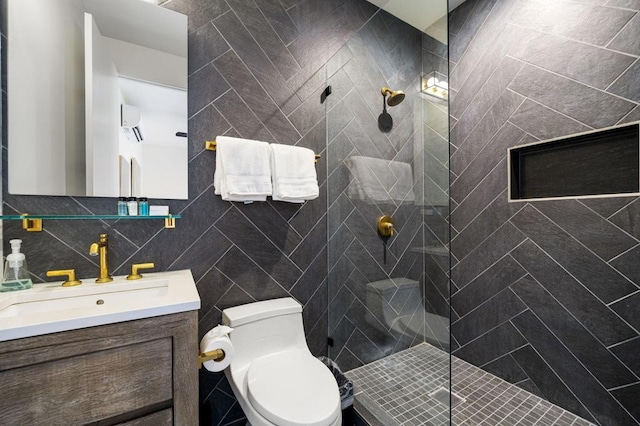 bathroom featuring vanity, toilet, tile walls, and a tile shower