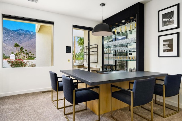 bar with hanging light fixtures, carpet, and a mountain view