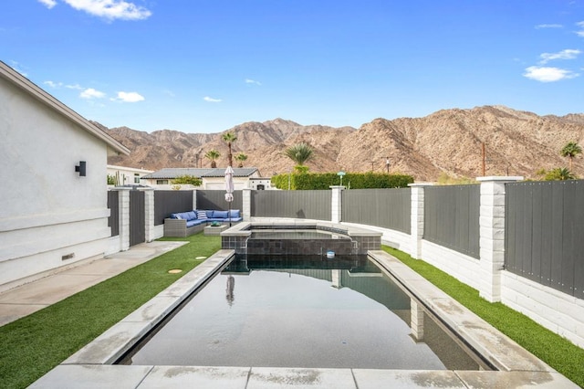 view of swimming pool featuring outdoor lounge area, a mountain view, and an in ground hot tub