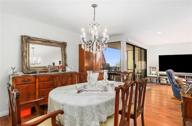 dining space with an inviting chandelier and light hardwood / wood-style floors