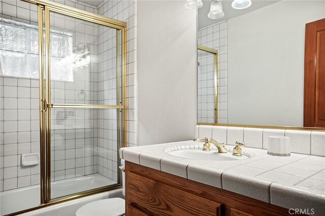 full bathroom with vanity, toilet, and combined bath / shower with glass door