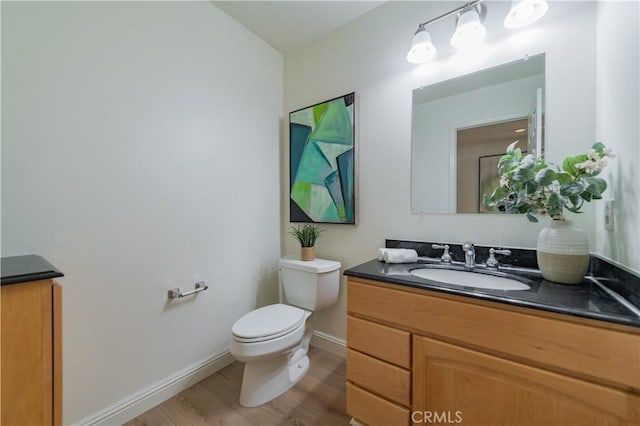 bathroom with vanity, toilet, and wood-type flooring