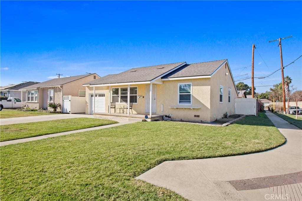 ranch-style house with a front yard, a porch, and a garage