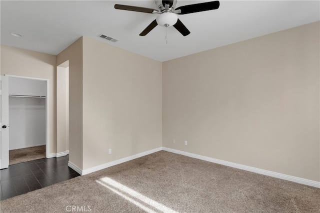 unfurnished bedroom with ceiling fan, a closet, and dark colored carpet