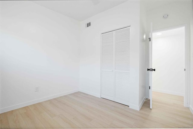 unfurnished bedroom with light wood-type flooring and a closet