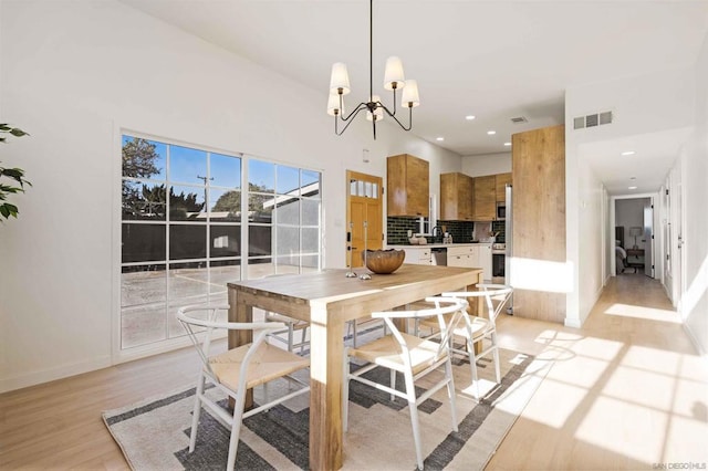 dining room with an inviting chandelier and light hardwood / wood-style flooring