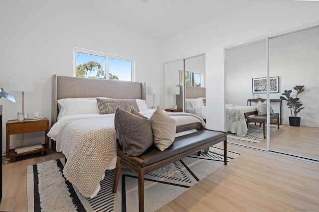 bedroom with multiple closets and light wood-type flooring