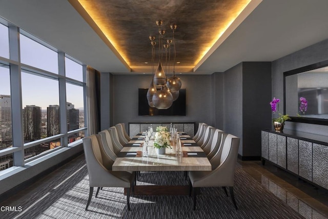 dining area featuring floor to ceiling windows and a tray ceiling