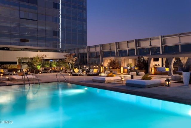 pool at dusk with a patio area