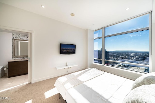 bedroom with light carpet and ensuite bath