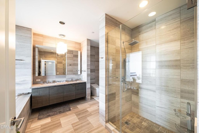 bathroom with walk in shower, vanity, toilet, and tile walls