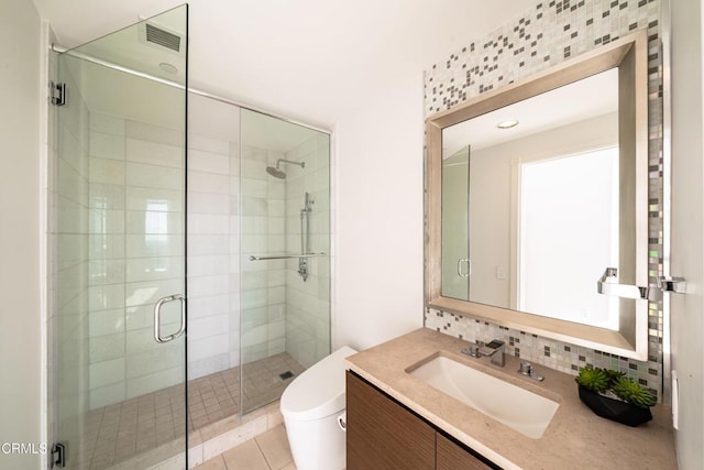 bathroom with backsplash, tile patterned floors, toilet, a shower with door, and vanity