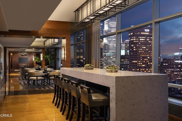 bar featuring stone countertops and floor to ceiling windows