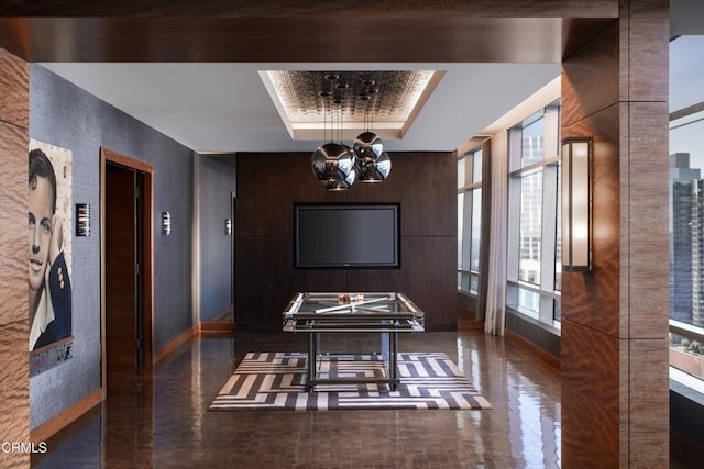 playroom featuring a raised ceiling and a chandelier