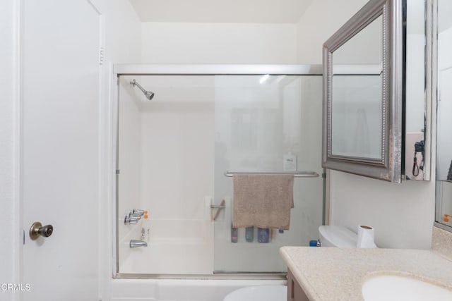 full bathroom featuring vanity, toilet, and combined bath / shower with glass door