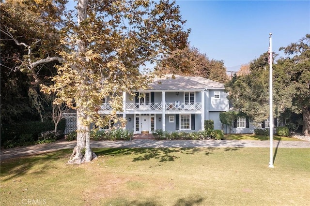 view of front of property featuring a front lawn and a balcony