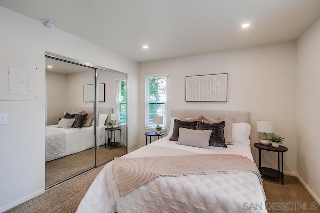 bedroom with dark carpet and a closet