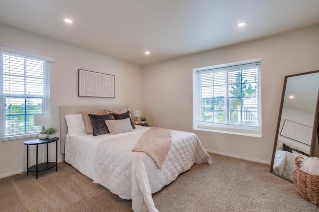 bedroom featuring light carpet and multiple windows