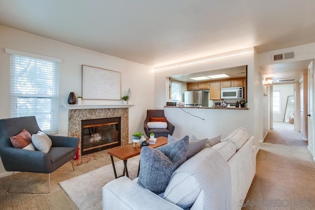 carpeted living room featuring a premium fireplace