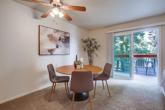 carpeted dining area with ceiling fan