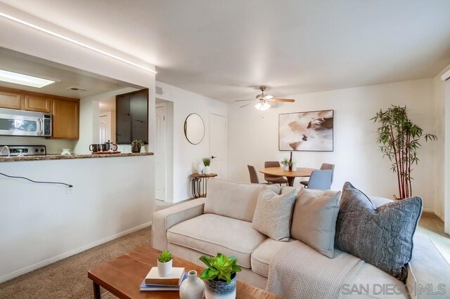 living room with light carpet and ceiling fan