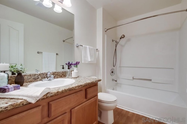 full bathroom featuring bathtub / shower combination, hardwood / wood-style floors, vanity, and toilet