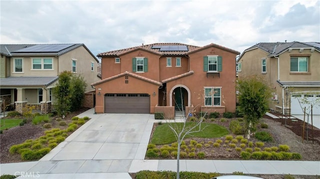 mediterranean / spanish house with solar panels, a garage, and a front lawn