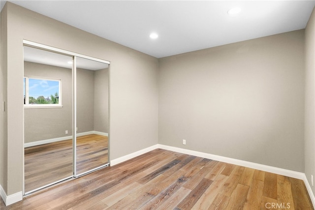 unfurnished bedroom with wood-type flooring and a closet