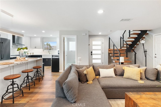 living room featuring light wood-type flooring and sink