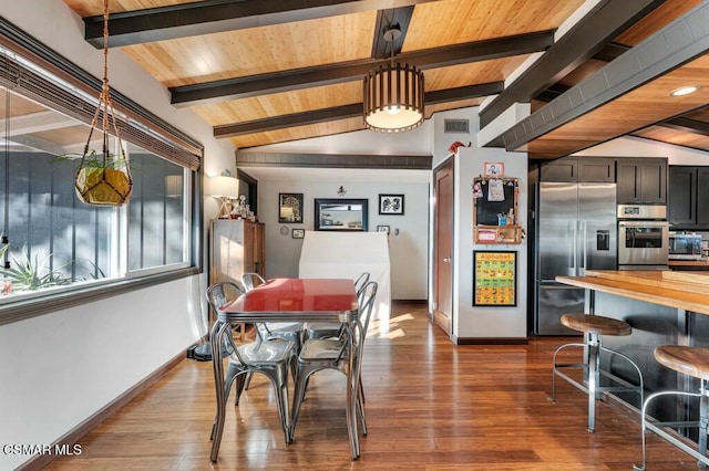 dining room featuring hardwood / wood-style floors and lofted ceiling with beams