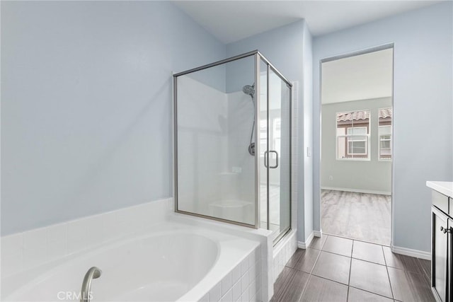 bathroom featuring tile patterned flooring, vanity, and shower with separate bathtub