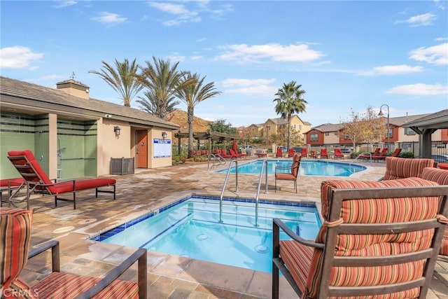 view of pool with a community hot tub and a patio