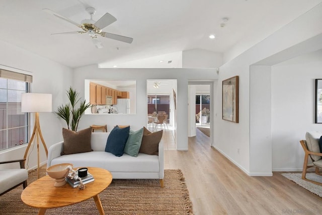 living room with ceiling fan, light hardwood / wood-style flooring, and lofted ceiling