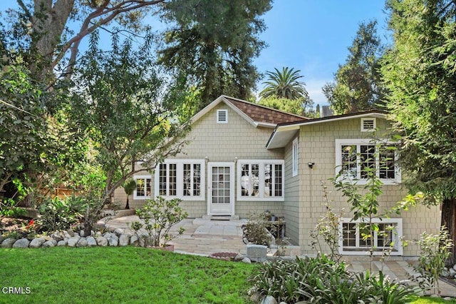 rear view of property with a lawn and a patio area