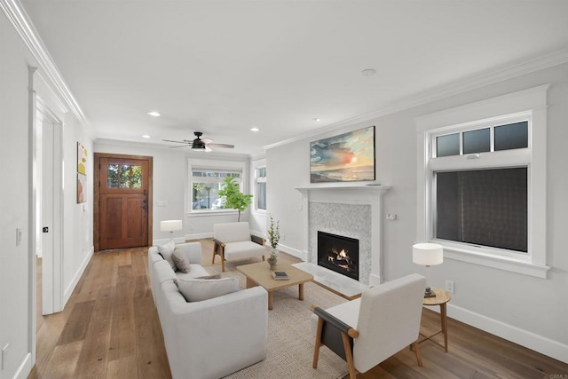 living room with light hardwood / wood-style floors, ceiling fan, and crown molding