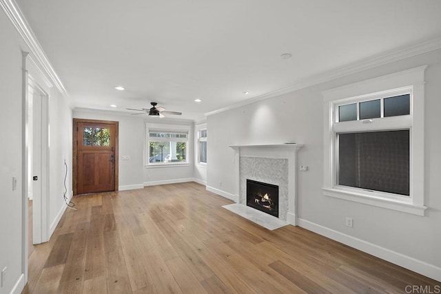 unfurnished living room featuring light wood-type flooring, ceiling fan, and crown molding