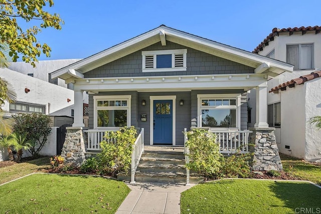 view of front of house with a porch and a front lawn