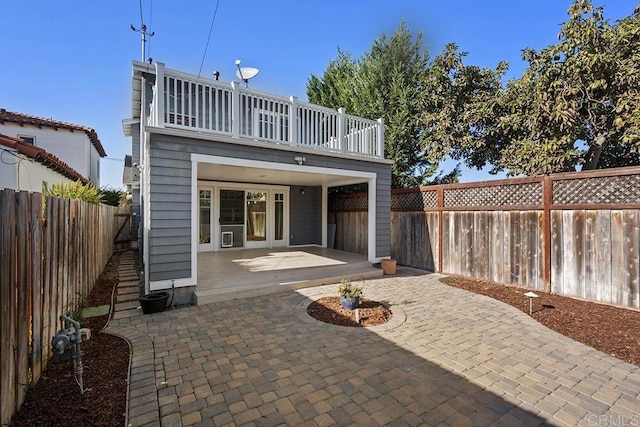 back of property featuring a patio area and a balcony