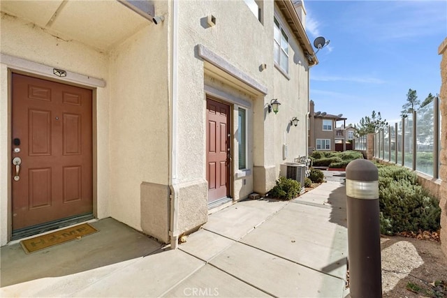 doorway to property featuring stucco siding