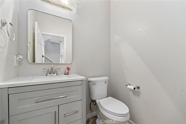 half bathroom with vanity and toilet