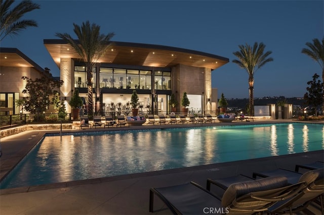 view of pool at twilight