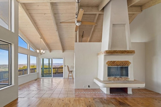 interior space featuring wood ceiling, ceiling fan with notable chandelier, and beamed ceiling