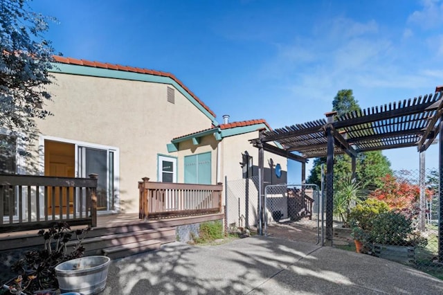 back of house featuring a pergola, a wooden deck, and a patio