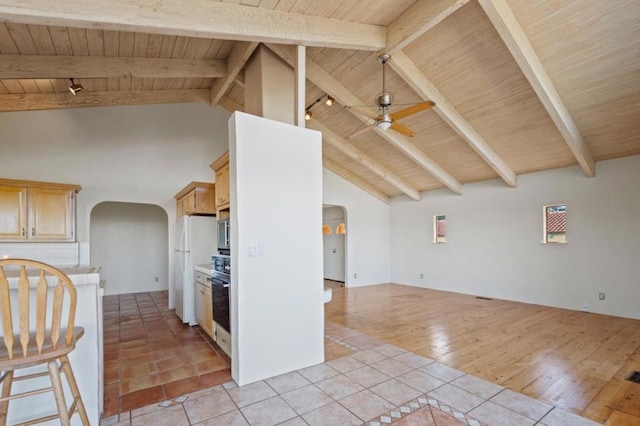 kitchen with ceiling fan, white fridge, beamed ceiling, light tile patterned flooring, and wood ceiling