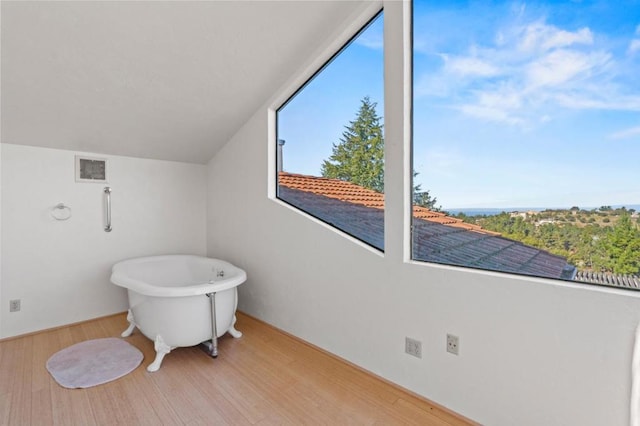 bathroom with hardwood / wood-style flooring and a tub