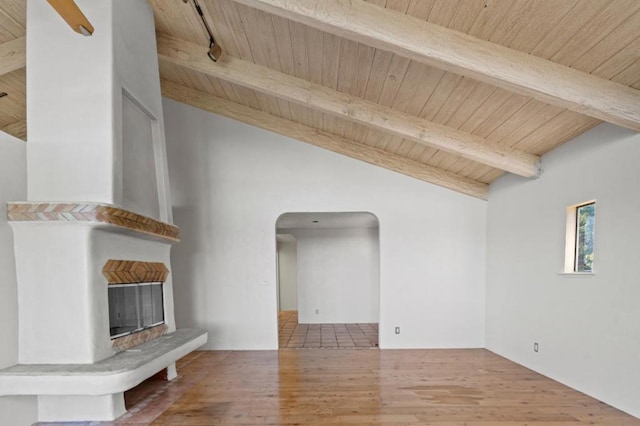 unfurnished living room with hardwood / wood-style floors, vaulted ceiling with beams, and wooden ceiling