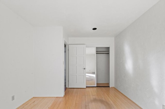 unfurnished bedroom featuring light hardwood / wood-style flooring and a closet